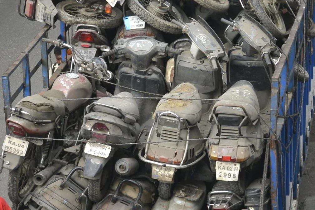 Old scooters and motorbikes stacked for recycling
