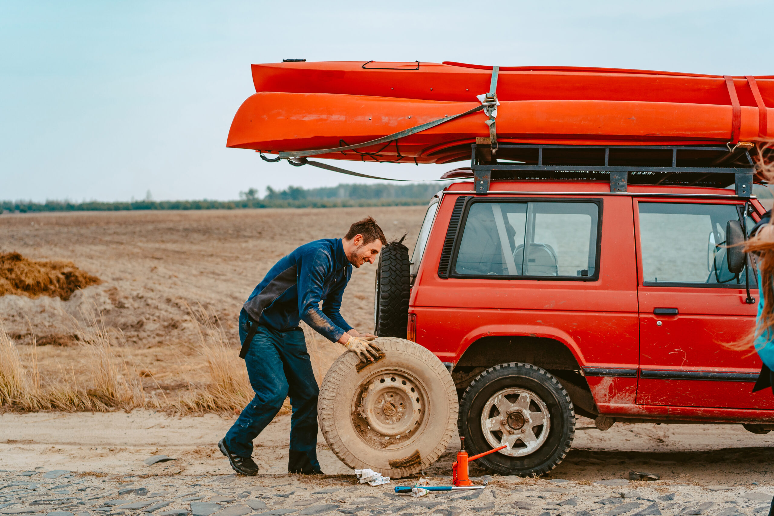 Man change the wheel manually on a 4x4 off road truck on the road