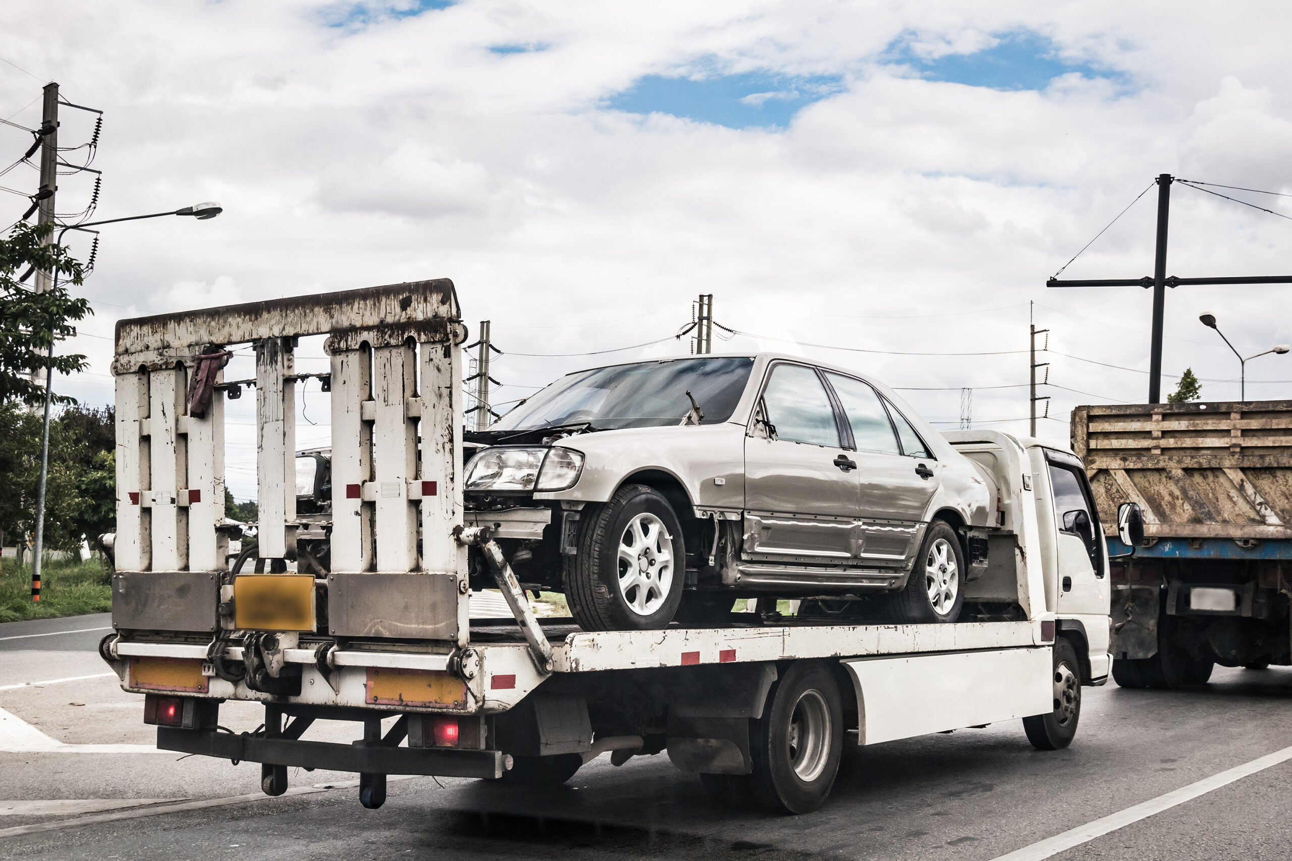Broken car on tow truck after traffic accident, on the road service