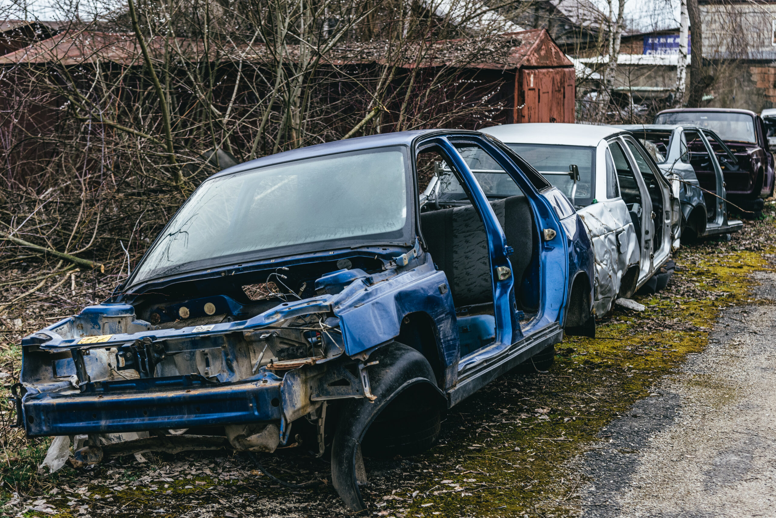 A dump of broken rusted cars, their parts and tires